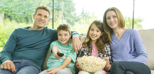 Familie beim Fernsehen im Wohnzimmer - CAIF18428