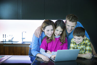 Family using laptop in kitchen - CAIF18429