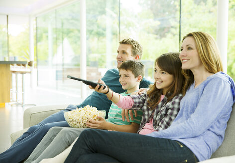 Familie beim Fernsehen im Wohnzimmer - CAIF18431