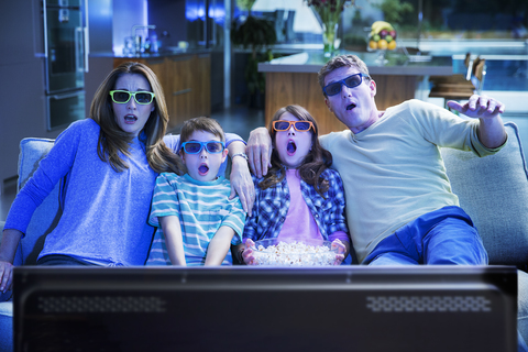 Familie beim 3D-Fernsehen im Wohnzimmer, lizenzfreies Stockfoto