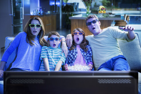 Familie beim 3D-Fernsehen im Wohnzimmer - CAIF18432