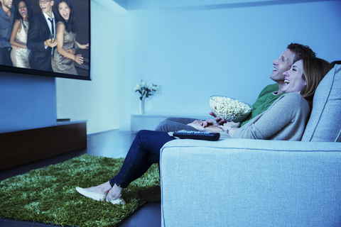 Ehepaar beim Fernsehen im Wohnzimmer, lizenzfreies Stockfoto