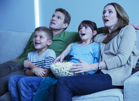 Familie beim Fernsehen im Wohnzimmer - CAIF18441