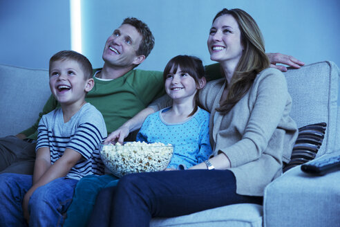 Familie beim Fernsehen im Wohnzimmer - CAIF18445