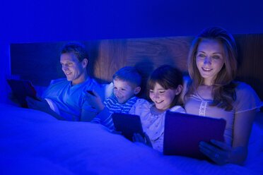 Familie nutzt Technologie im Bett - CAIF18449