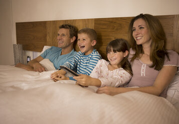 Familie beim Fernsehen im Bett - CAIF18451
