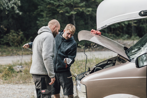 Kanada, British Columbia, zwei Männer prüfen den Ölstand eines Minivans, lizenzfreies Stockfoto