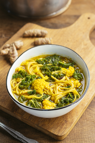 Turmeric broth, detox soup with soba noodles, kale, cauliflower and chickpeas stock photo