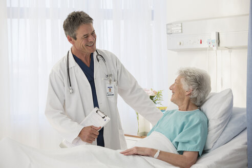 Arzt im Gespräch mit einem älteren Patienten im Krankenhaus - CAIF18498
