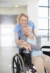 Porträt einer lächelnden Krankenschwester und eines älteren Patienten im Rollstuhl - CAIF18499