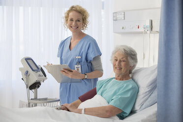 Porträt einer lächelnden Krankenschwester und eines älteren Patienten in einem Krankenhauszimmer - CAIF18509