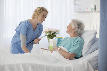 Krankenschwester und alternder Patient im Gespräch im Krankenhauszimmer - CAIF18514
