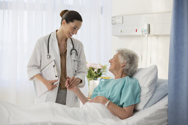 Arzt und älterer Patient unterhalten sich in einem Krankenhauszimmer - CAIF18532