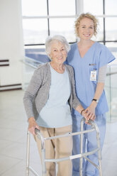 Porträt einer lächelnden Krankenschwester und eines älteren Patienten mit Gehhilfe - CAIF18537