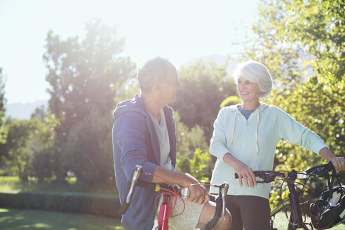 Senior couple with bicycles in park - CAIF18590