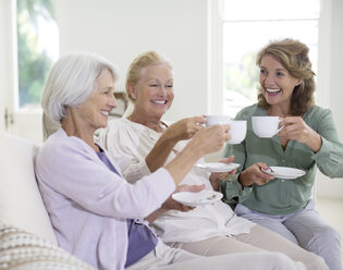 Senior women toasting coffee cups - CAIF18604