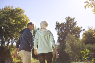 Älteres Paar hält sich an den Händen und geht im Park spazieren - CAIF18610