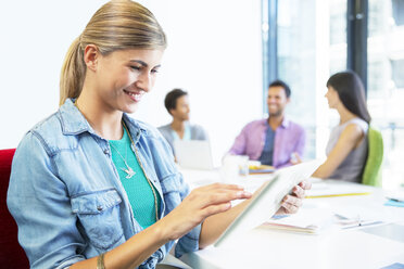 Businesswoman using digital tablet in meeting - CAIF18622