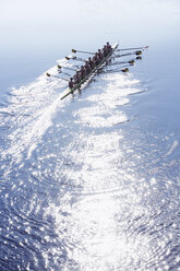 Rowing team rowing scull on sunny lake - CAIF18635