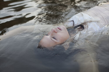 Woman floating in lake - CAIF18668