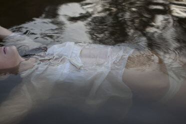 Woman floating in lake - CAIF18675