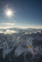 Austria, Salzkammergut, Hot air balloons over alpine landscape in winter - STC00389