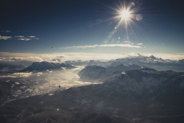Austria, Salzkammergut, Hot air balloons over alpine landscape in winter - STCF00395