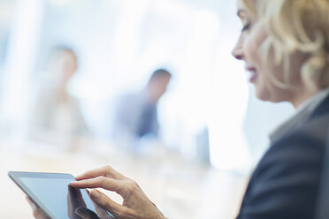 Businesswoman using digital tablet in office - CAIF18719