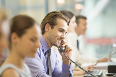 Businessman talking on telephone in office - CAIF18737