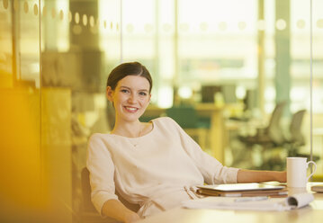 Businesswoman smiling in office - CAIF18740