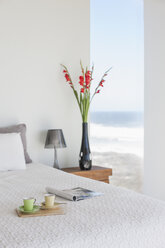 Frühstückstablett auf dem Bett im modernen Schlafzimmer mit Meerblick - CAIF18788