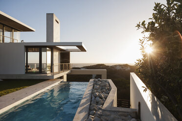 Modern house overlooking beach at sunset - CAIF18814