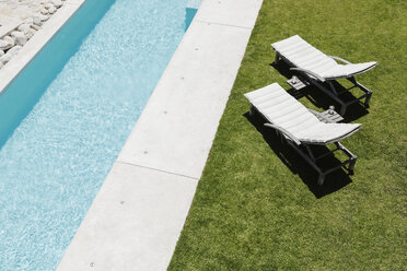 Liegestühle auf dem Rasen entlang des Schwimmbeckens - CAIF18815