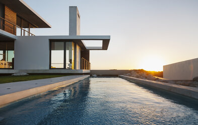 Lap pool outside modern house at sunset - CAIF18819