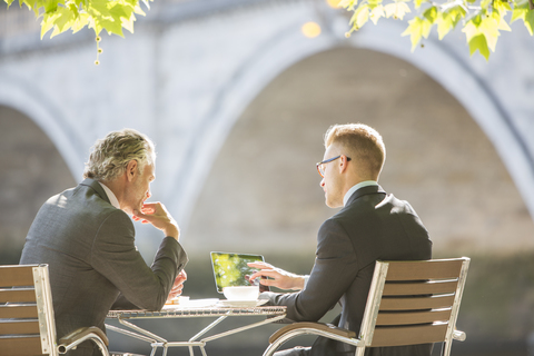 Geschäftsleute arbeiten in einem Straßencafé, lizenzfreies Stockfoto