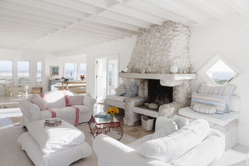 Sofas und Kamin im weißen Wohnzimmer - CAIF18846