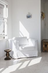 Sun shining on white armchair in corner - CAIF18859