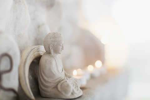 Buddha-Figur und Kerzen auf Sims, lizenzfreies Stockfoto