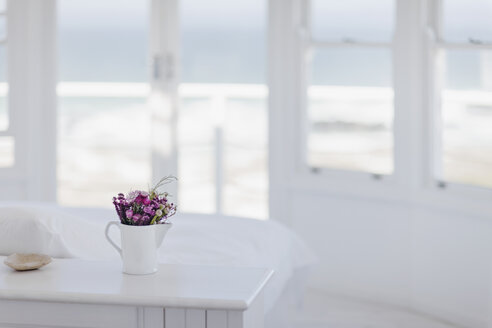 Blumenvase auf dem Schreibtisch im Schlafzimmer mit Blick aufs Meer - CAIF18870