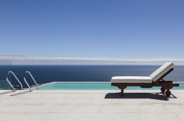 Infinity-Pool und Liegestuhl mit Blick aufs Meer - CAIF18960