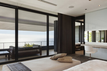Modern bedroom and balcony overlooking ocean - CAIF18972