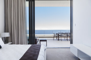 Modern bedroom and balcony overlooking ocean - CAIF18974