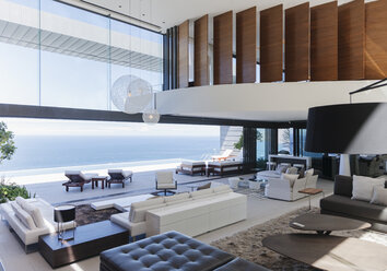 Modern living room overlooking ocean - CAIF18975