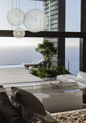 Sofas und Tische im modernen Wohnzimmer mit Blick aufs Meer - CAIF19018