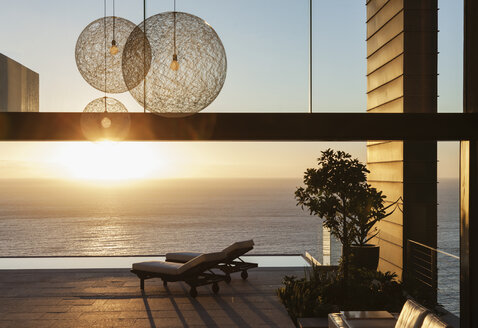 Terrasse eines modernen Hauses mit Blick auf das Meer bei Sonnenuntergang - CAIF19043