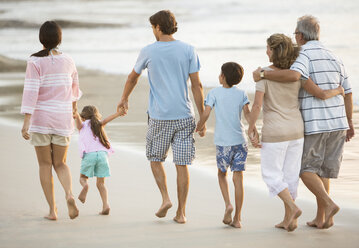 Mehrgenerationenfamilie hält sich am Strand an den Händen - CAIF19122