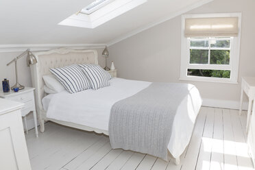 Bed in whitewashed attic bedroom - CAIF19240