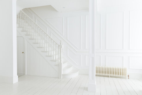 Weißes Treppenhaus und weiße Wände in einem verschnörkelten Haus - CAIF19248