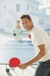 Couple playing table tennis outdoors - CAIF19285