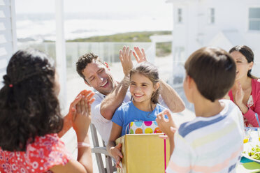 Familie feiert Geburtstag auf sonniger Veranda - CAIF19314